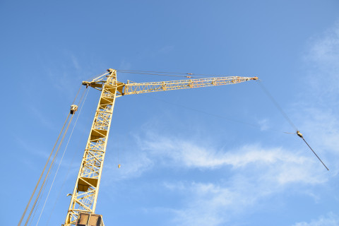 yellow building crane against blue sky